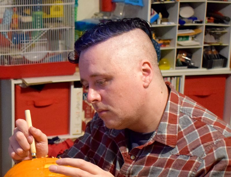 Ken carving a pumpkin