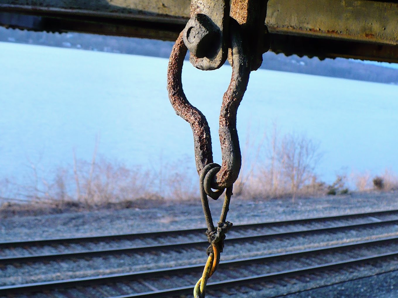 A broken chain in front of train tracks